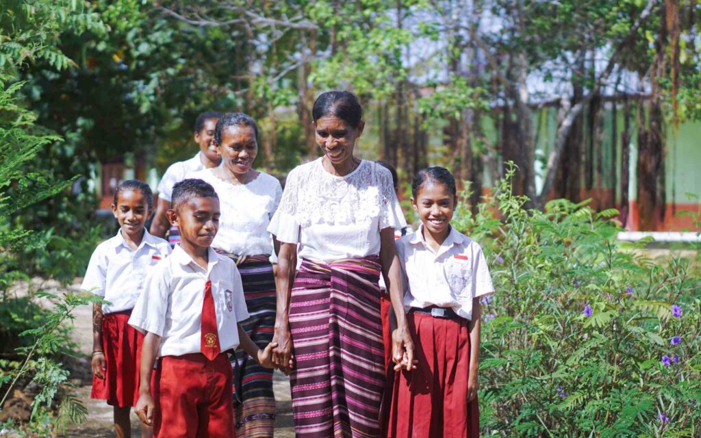 Wanita penganyam Flores NTT sedang mengantarkan anak-anak mereka berangkat ke sekolah, sambil mengenakan sarung tenun khas NTT