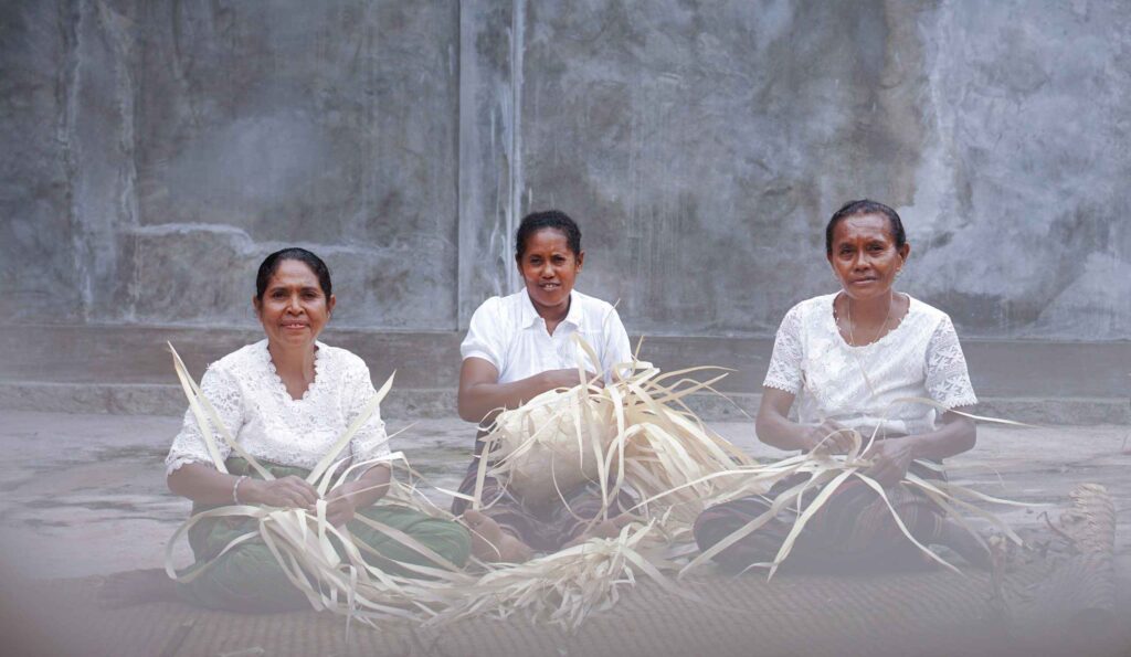 Tiga wanita Flores NTT sedang menganyam anyaman keranjang dari daun lontar