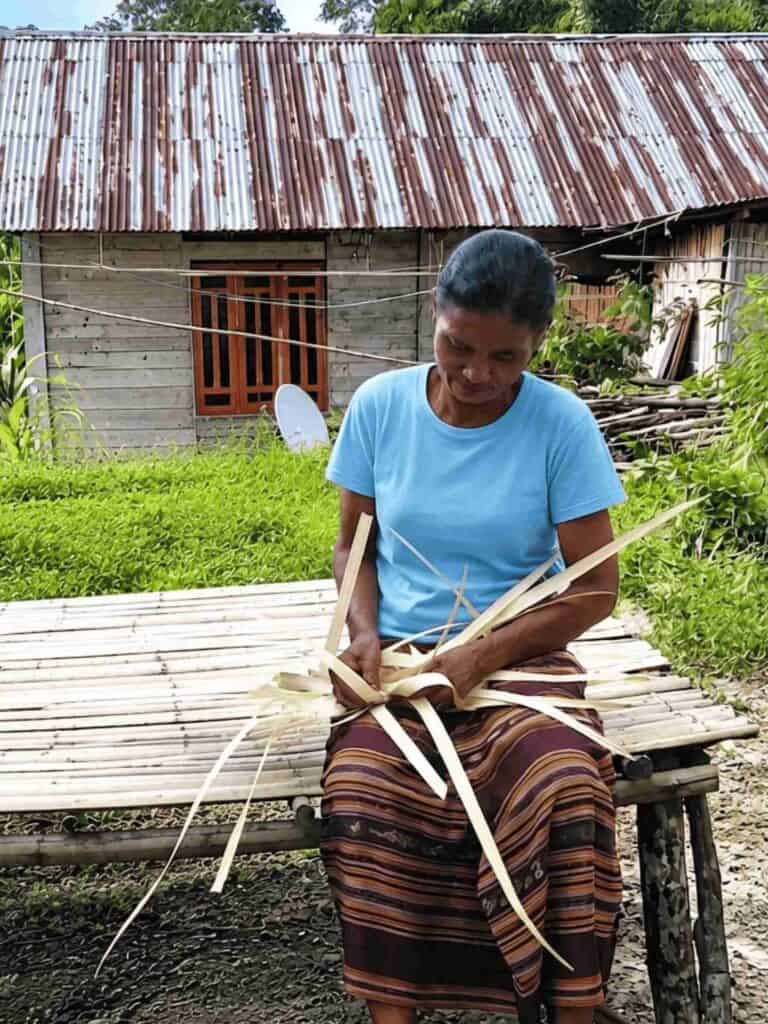 Mama Nogo weaving lontar palm leaf plait